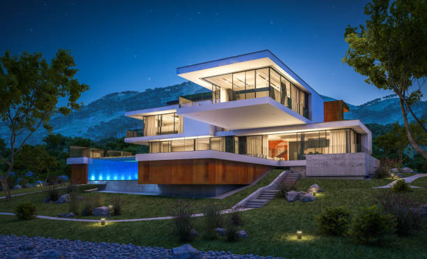 Modern luxury home built on a sloping block at night with mountain views